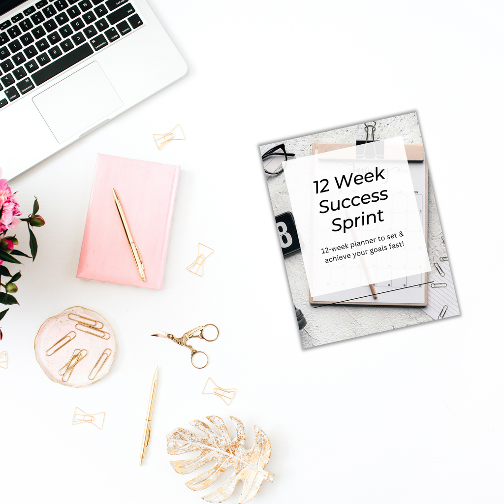 Flat lay of office items: a laptop, pink notepad, pen, paper clips, scissors, and a 12-Week Success Sprint Planner PLR Template on a white surface with a pink flower.