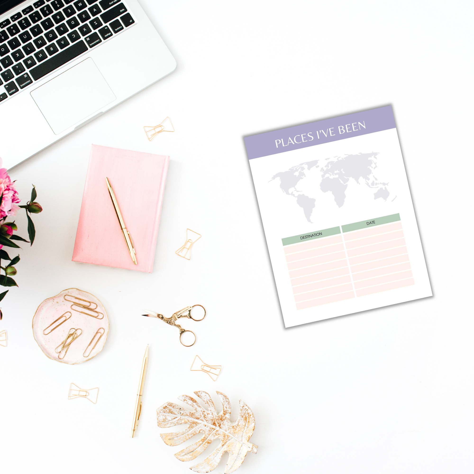 A laptop, pink notebook, pen, decorative items, and "The Dream Vacations Travel Planner" sit elegantly on a white desk.