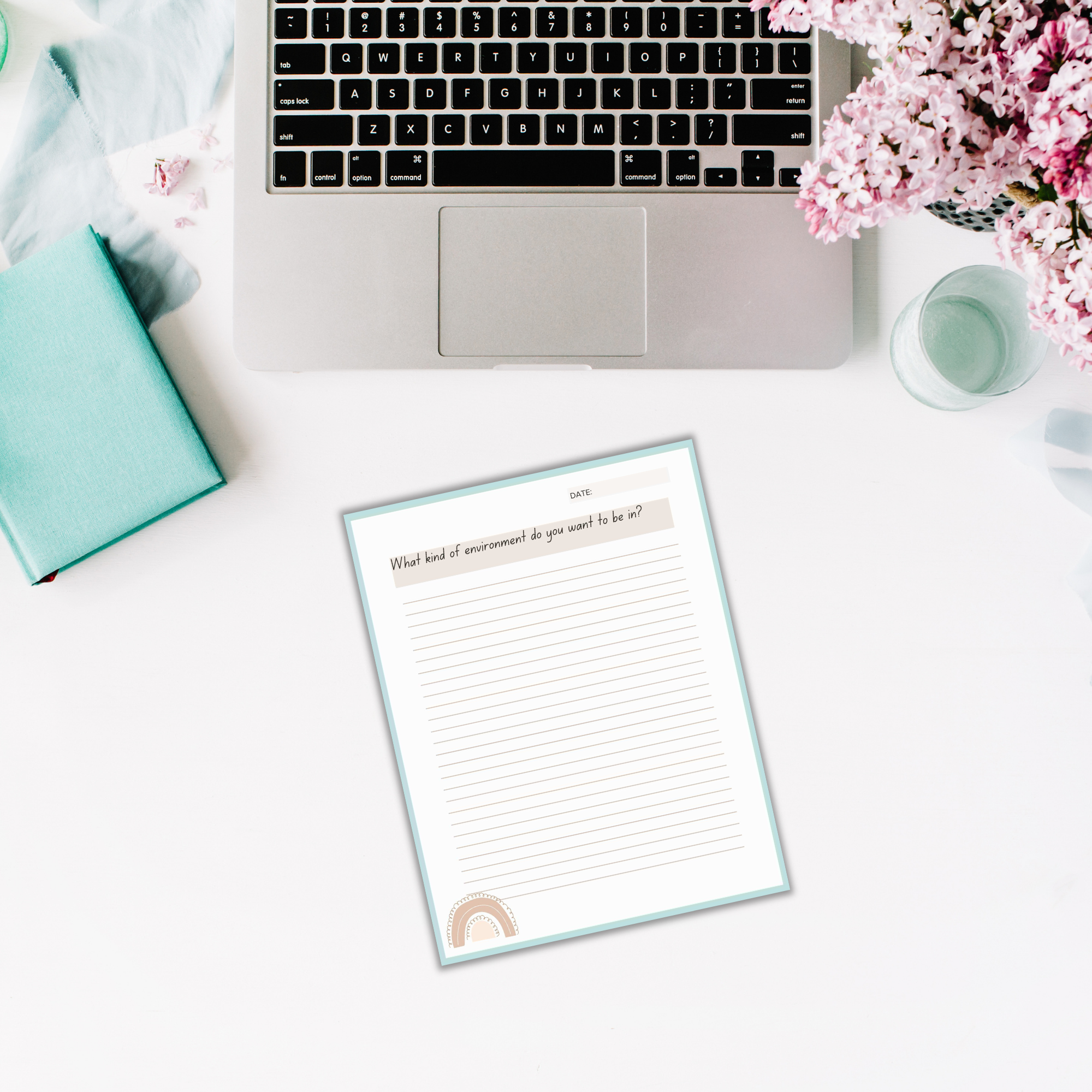 A laptop, open notebook, flowers, and a turquoise book are placed on a white desk. An empty 'Find Your Purpose' Journal with lined paper is titled "What kind of environment do you want to be in?
