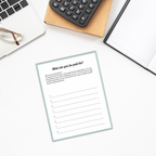 A cozy desk setup, featuring a laptop, glasses, calculator, and notebook, is primed for productivity. A worksheet from The 'Find Your Purpose' Ebook & Workbook titled "What can you be paid for?" lies open, encouraging exploration of writing tasks and the discovery of purpose in every opportunity.