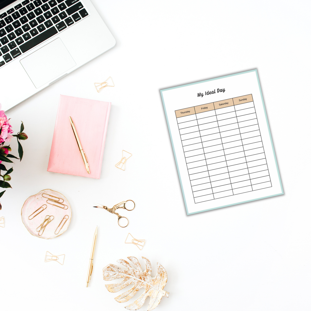 A flat lay showcases a laptop, pink notebook, pen, gold paperclips, scissors, and a white leaf decoration accenting the blank weekly planner sheet titled "My Ideal Day." It's the perfect setup to explore The 'Find Your Purpose' Ebook & Workbook.