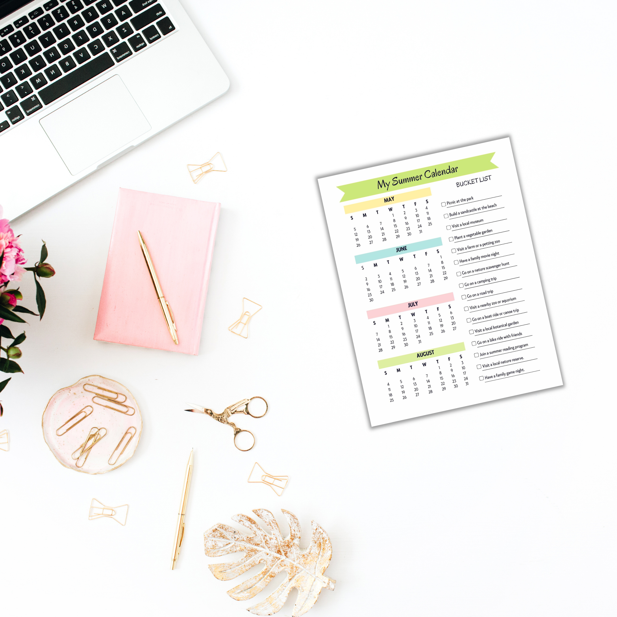 A laptop, pink notebook, pen, and flower are arranged beside an open planner featuring a summer calendar and checklist, all elegantly placed on a white surface—ideal for organizing your Summer Bundle for Kids activities.