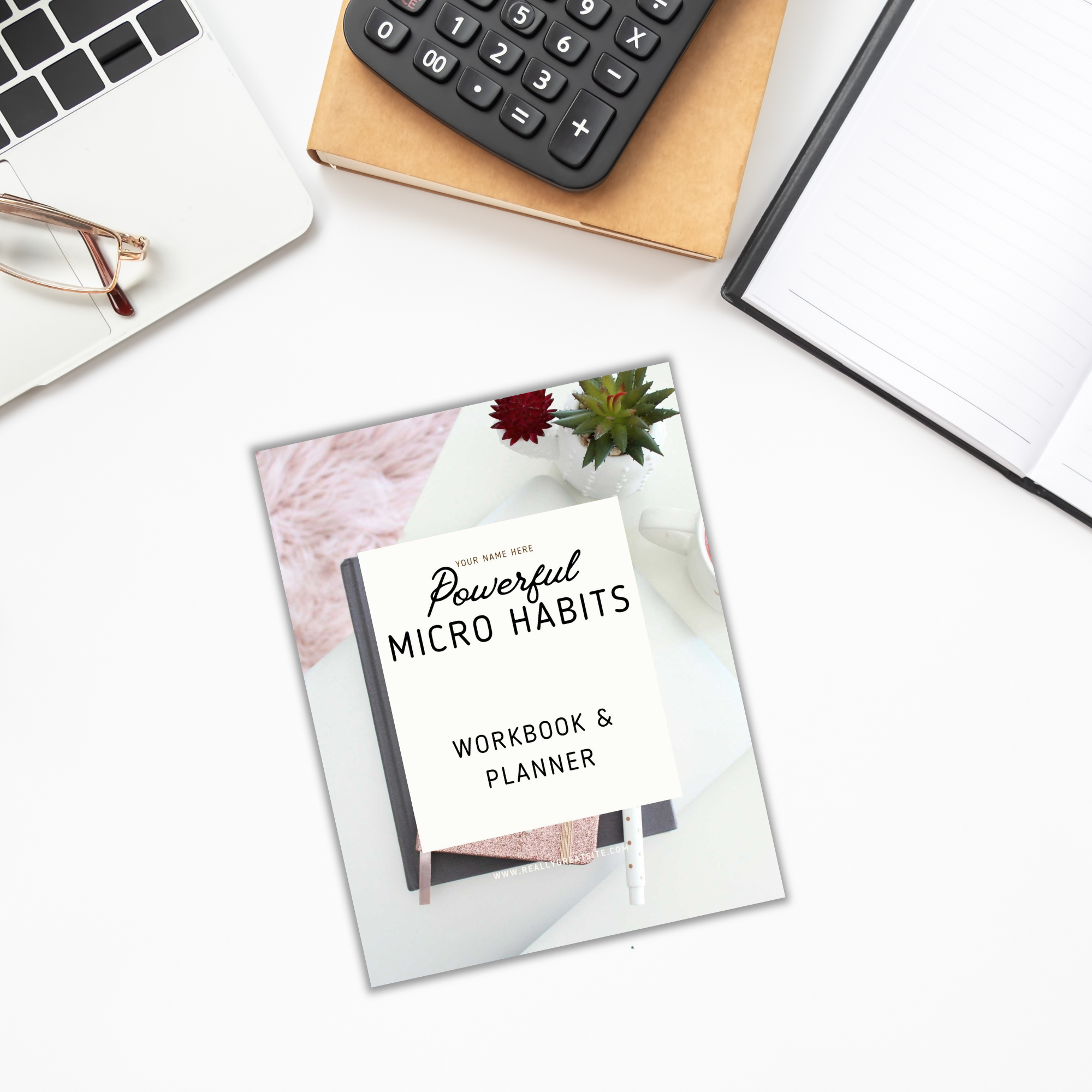 On a white desk in the workspace, you'll find the "Powerful Micro Habits - Ebook & Workbook" alongside a calculator, notepad, and glasses.