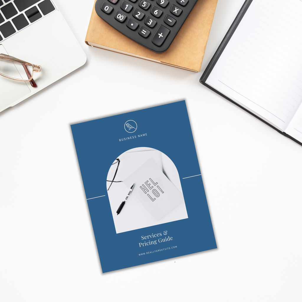 A blue brochure titled "Services and Pricing Guide" rests on the desk alongside a pen, notebook, glasses, and calculator—your essential toolkit for navigating our services.