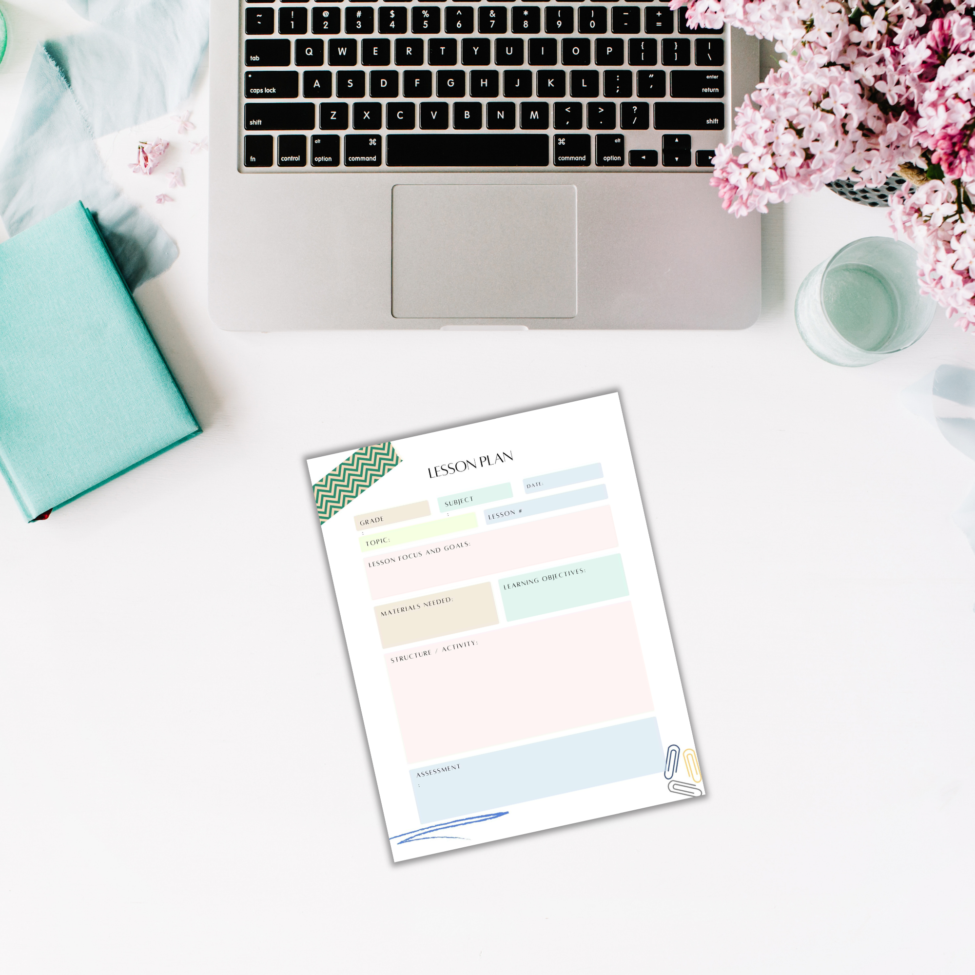 An open laptop and a lesson plan sheet rest on a white surface, accompanied by the Printable Planner for Teachers, a book, a candle, and pink flowers—ideal for teachers seeking inspiration.