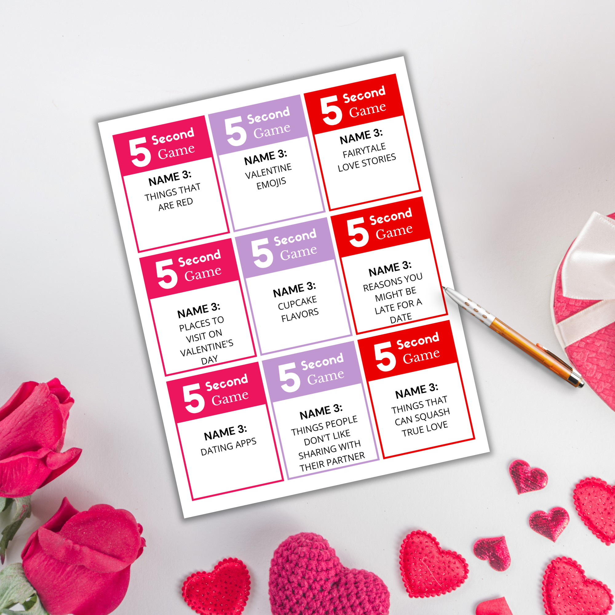 A "Valentine's 5-Second Game PLR" card lies on a white surface, surrounded by red and pink roses, a heart-shaped pen, and crocheted hearts, featuring Valentine-themed prompts to spark joy.